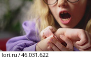 Cheerful girl wearing pink smartwatch lies on bed and explores its features. Gadget combines fun and functionality, perfect for young explorers. Colorful design adds excitement to learning moments. Стоковое видео, видеограф Енваев Андрей / Фотобанк Лори