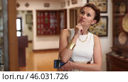 Woman with phone in hands walks around museum hall, view exhibition. Стоковое видео, видеограф Яков Филимонов / Фотобанк Лори