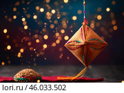 Hanging akash kandil illuminating the festive atmosphere of diwali with blurred lights in the background. Стоковое AI-изображение, AI-художник Иван Рябоконь / Фотобанк Лори
