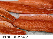 Raw fresh layers of Atlantic salmon lie on shallow ice at the seafood market. An open shelf at the fish market. Стоковое фото, фотограф worker / Фотобанк Лори