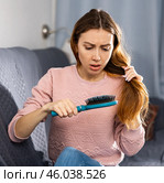 Frustrated young woman combs her hair. Стоковое фото, фотограф Яков Филимонов / Фотобанк Лори
