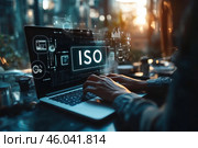 На голографическом дисплее ноутбука, за которым работает человек, выделяются крупные буквы ISO. Стоковое AI-изображение, AI-художник Ярославский Максим / Фотобанк Лори
