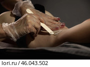 Cosmetologist applying liquid sugar paste by spatula, beauty treatment, removing hair procedure. Epilation underarm with hot wax paste on armpit. Smooth skin, health care concept. Copy ad text space. Стоковое фото, фотограф Aleksandr Golubev / Фотобанк Лори
