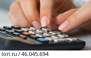 Hands actively utilizing a calculator to perform financial calculations. Closeup hands pressing calculator buttons. Calculate tax income and expenses, bills, credit card for payment or payday at home. Стоковое AI-видео, аниматор Марина Демидюк / Фотобанк Лори
