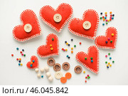 Красные сердечки на белом фоне. Изолированные сердечки на белом фоне. Фон к дню святого валентина. Красные сердечки из фетра. Red hearts on white background. Isolated hearts on white background. Valentine's Day background. Red felt hearts. Стоковое фото, фотограф Ольга Митряева / Фотобанк Лори