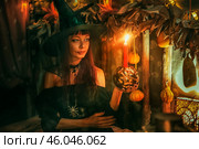 Женщина в костюме ведьмы держит свечу. Хэллоуин. Стоковое фото, фотограф Марина Володько / Фотобанк Лори