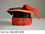 Graduation doctoral mortarboard cap sitting on tabletop. Стоковое AI-изображение, AI-художник Иван Рябоконь / Фотобанк Лори