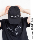 A girl in a black baseball cap with the inscription infuriate and a black T-shirt with cats (2023 год). Редакционное фото, фотограф Алексей Львов / Фотобанк Лори