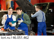 Car service manager discusses car repair problems with mechanic. He takes notes on paper. Стоковое фото, фотограф Яков Филимонов / Фотобанк Лори
