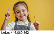 Cheerful child pointing on yellow background in playful sequence. Стоковое AI-видео, аниматор Zakharova Natasha / Фотобанк Лори