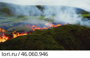 Dramatic volcanic eruption with flowing lava and rising smoke in scenic landscape. Стоковое AI-видео, аниматор Zakharova Natasha / Фотобанк Лори