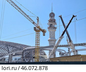 Строительство нового железнодорожного вокзала в городе Грозный, Чеченская Республика, Россия. Вид на строительные краны и высокую башню строящегося вокзала. Реконструкция железнодорожной станции и возведение современного вокзального комплекса в Чечне. Развитие транспортной инфраструктуры на Северном Кавказе. (2024 год). Редакционное фото, фотограф Андрей Степанов / Фотобанк Лори