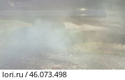 Thick plumes of exhaust smoke billow from the tailpipe of a vehicle, shrouding the surrounding natural landscape in an obscuring haze. Slow motion. An old car is poisoning the air. Стоковое видео, видеограф Воловодов Владимир / Фотобанк Лори