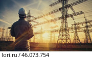 Professional electrician with blueprint and helmet near high voltage tower, close-up. Overhead power line pylons, high voltage pylons. Power transmission towers and lines at sunset. Photo of high voltage transmission tower, also known as transmission tower. Стоковое видео, видеограф ALLA YURTAYEVA / Фотобанк Лори