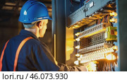 Male electrician working in switchboard with electrical connecting cable. Work in repair shops and maintenance services. Stress, nerves. Стоковое видео, видеограф ALLA YURTAYEVA / Фотобанк Лори
