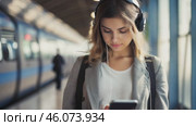 Young girl listen music in headphones and hold smartphone in subway car travel underground use wireless internet connection. Happy female chatting online in mobile phone messenger watch video in metro. standing on the railway station crossing near the train. Стоковое видео, видеограф ALLA YURTAYEVA / Фотобанк Лори