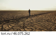 Man on cracked earth in desert. Water problems, global warming, drought, water shortage in the world, health problems, poverty and misery in countries. Climate change: from friendship to green grove. Стоковое AI-видео, аниматор ALLA YURTAYEVA / Фотобанк Лори