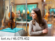 Interested brunette visiting exhibition of medieval musical instruments in museum. Стоковое фото, фотограф Яков Филимонов / Фотобанк Лори