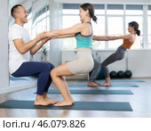 Women and men performing paired yoga exercises during group training at gym. Fitness and pair Hatha yoga concept. Стоковое фото, фотограф Яков Филимонов / Фотобанк Лори