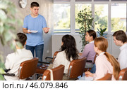 Positive student answering at lesson in front of groupmates. Стоковое фото, фотограф Яков Филимонов / Фотобанк Лори