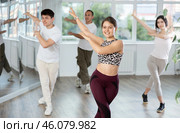 Smiling young people practicing vigorous lindy hop movements in dance class. Стоковое фото, фотограф Яков Филимонов / Фотобанк Лори