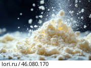 A close-up of the crumbly texture of a powdery product, similar to flour, powdered sugar or powdered milk. The focus is on a small mountain of powder, with tiny particles floating in the air, creating an effect of suspension and movement. The lighting emphasizes the softness of the structure, and the contrasting dark background adds depth and expressiveness. The atmosphere of the image is reminiscent of a culinary process, such as sifting flour or making desserts. Стоковое AI-изображение, AI-художник Анна Кривицкая / Фотобанк Лори