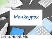 The word Monkeypox VIRUS on Gray modern doctor desk table background. Mask, notepad, syringe, blue gloves and supplies. Monkey pox spreading. Medicine and healthcare, medical education. Top view. Стоковое фото, фотограф Марина Демидюк / Фотобанк Лори