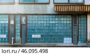 The facade of an old industrial building with windows of small square glasses. Uneven cracked surface. Perfect for background and grunge design. Стоковое фото, фотограф Андрей Степанов / Фотобанк Лори