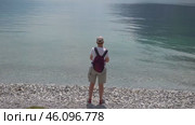 Турист на берегу озера Гарда. Город Рива дель Гарда. Италия. Май. Tourist on the shore of Lake Garda. City Riva del Garda. Italy. May. Редакционное видео, видеограф Горшков Александр / Фотобанк Лори