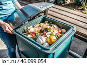 An open compost container with peels and fruit and vegetable clippings. Organic waste in a garden composter. Eco-friendly gardening, sustainability, ecology. Стоковое AI-изображение, AI-художник Photojuli / Фотобанк Лори