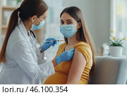 Pregnant Vaccination. Young Pregnant Woman In Face Mask Getting Vaccinated in Clinic. Doctor Giving Corona Virus Vaccine Injection to Female Patient with Belly. Covid-19 Flu Protection. Dengue fever. Стоковое AI-изображение, AI-художник Марина Демидюк / Фотобанк Лори