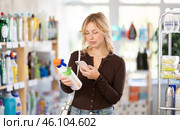 Before making purchase, girl buyer scan QR code on packaging of glass cleaner spray. Стоковое фото, фотограф Яков Филимонов / Фотобанк Лори