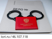 Удостоверение адвоката и наручники на папке Дело. Стоковое фото, фотограф fotobelstar / Фотобанк Лори