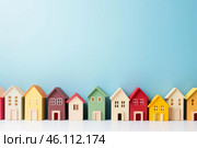 Row of colorful wooden toy houses on blue background. Стоковое AI-изображение, AI-художник Иван Рябоконь / Фотобанк Лори