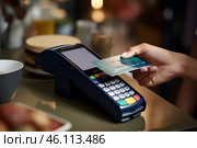 A woman makes a contactless payment at a cafй during lunchtime, using her card at the point of sale device. Стоковое AI-изображение, AI-художник Sergey Grishin / Фотобанк Лори
