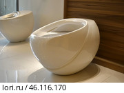 Modern oval toilets showing innovative design in restroom. Стоковое AI-изображение, AI-художник Иван Рябоконь / Фотобанк Лори
