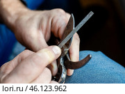 A man sharpens the blade of a garden pruner with a file. Garden tools. Стоковое фото, фотограф Коханова Наталья / Фотобанк Лори