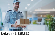 Delivery man holding package smiling in office building. Стоковое AI-видео, аниматор Юрий Поздников / Фотобанк Лори