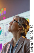Businesswoman observing increasing graph on big screen in office at night. Стоковое AI-видео, аниматор Юрий Поздников / Фотобанк Лори