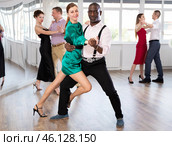 Woman dances incendiary tango with African man partner during choreography lesson. Стоковое фото, фотограф Яков Филимонов / Фотобанк Лори