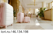 Travel bags in modern hotel lobby with blurred receptionists. Стоковое AI-изображение, AI-художник Анастасия Золотницкая / Фотобанк Лори