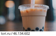 Bubble tea in a plastic cup with a straw. Стоковое видео, видеограф Данил Руденко / Фотобанк Лори