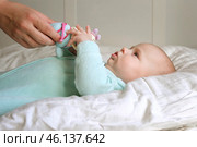 Cute Newborn Baby Lying on the Back and Plays with Colorful Toys. Little Three Month Child Takes a Toy. Portrait of Playful Neonate Toddler. Concept of Childhood, New Life, Baby Care. Top View. Стоковое фото, фотограф Марина Демидюк / Фотобанк Лори