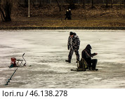 Зимняя рыбалка в черте города Москва/ Men ice fishing on a frozen lake. Men engaged in winter fishing on the lake in Moscow, Russia. Редакционное фото, фотограф Iva Noel / Фотобанк Лори