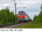 Электровоз ВЛ80с с грузовым поездом  на однопутном участке облачным летним днем. Северная железная дорога (2019 год). Редакционное фото, фотограф Виктор Карасев / Фотобанк Лори