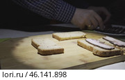 Men's hands spread slices of smoked bacon on grain bread. Стоковое видео, видеограф Ярославский Максим / Фотобанк Лори