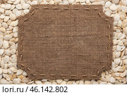 Frame made of burlap with stitches and place for your text lying on pumpkin seeds. Стоковое фото, фотограф Александр Собко / Фотобанк Лори