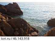 Waves gently crash against the rugged rocks while the sun sets over the horizon. Experience the serene beauty of this coastal location filled with natural wonders. Canj, Montenegro, Adriatic sea (2024 год). Стоковое фото, фотограф Юлия Петровская / Фотобанк Лори