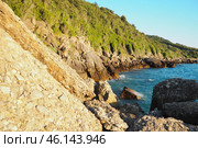 Waves gently crash against the rugged rocks while the sun sets over the horizon. Experience the serene beauty of this coastal location filled with natural wonders. Canj, Montenegro, Adriatic sea (2024 год). Стоковое фото, фотограф Юлия Петровская / Фотобанк Лори
