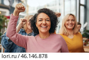 Mixed race women with raised fists of empowerment, strength and women solidarity, International Womens Day concept. Стоковое AI-изображение, AI-художник Анастасия Золотницкая / Фотобанк Лори